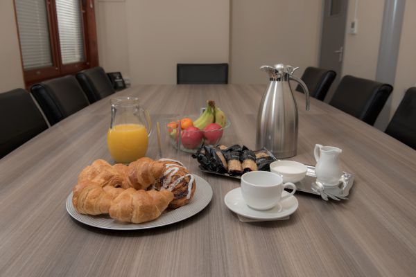 croissants-fruit-coffee-and-juice-on-meeting-table