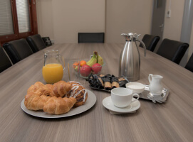 croissants-fruit-coffee-and-juice-on-meeting-table